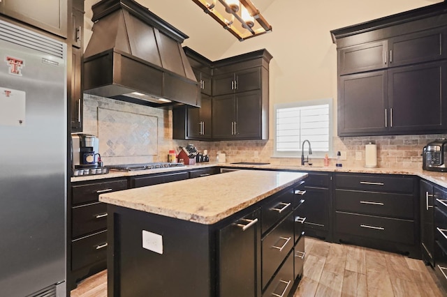 kitchen with premium range hood, appliances with stainless steel finishes, a center island, and backsplash