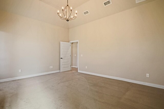 spare room with carpet and an inviting chandelier