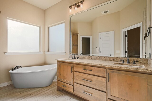 bathroom featuring a washtub and vanity