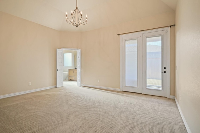 carpeted empty room featuring a chandelier