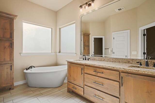 bathroom featuring vanity and a bath