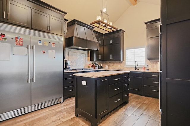 kitchen featuring premium range hood, tasteful backsplash, a center island, pendant lighting, and stainless steel appliances