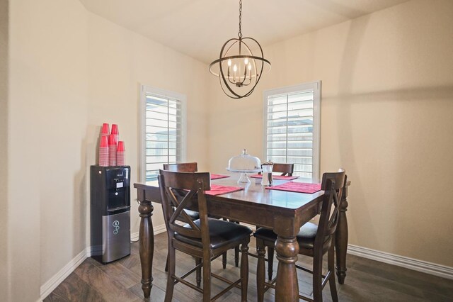 dining room with dark hardwood / wood-style flooring and a chandelier