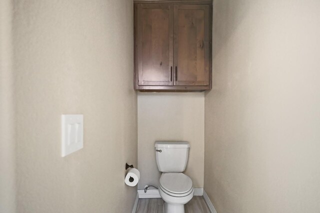 bathroom featuring hardwood / wood-style floors and toilet