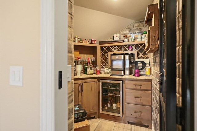 bar featuring lofted ceiling and wine cooler