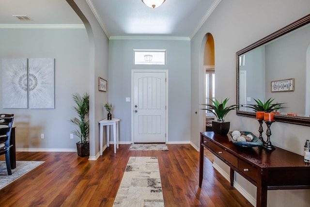 foyer entrance with visible vents, crown molding, arched walkways, and wood finished floors