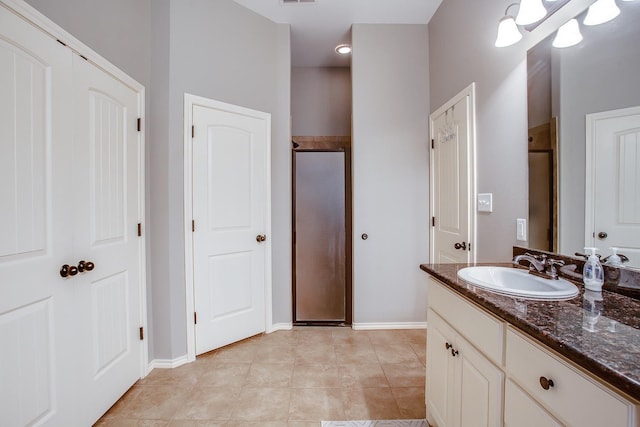 full bath featuring tile patterned flooring, baseboards, a shower stall, and vanity