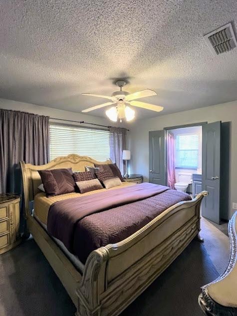 bedroom featuring ceiling fan, a textured ceiling, and dark colored carpet