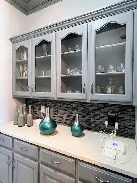 bar featuring tasteful backsplash and gray cabinetry