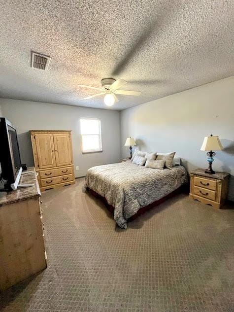 carpeted bedroom featuring ceiling fan and a textured ceiling