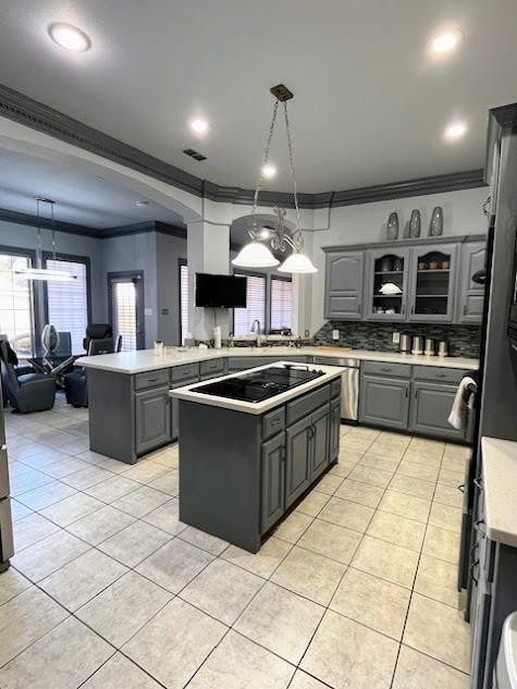 kitchen featuring gray cabinetry, black electric stovetop, hanging light fixtures, and a kitchen island