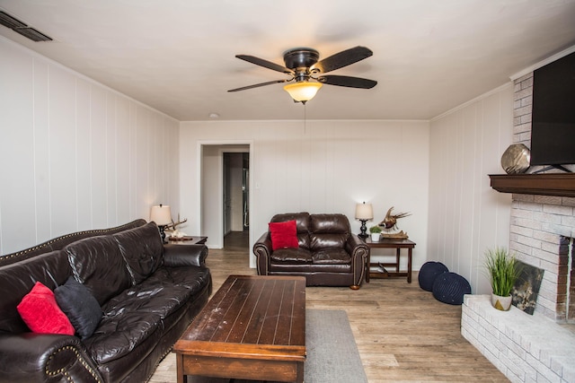 5303 46th St, Lubbock, TX 79414 - living area with ceiling fan, ornamental molding, visible vents, wood finished floors, and a brick fireplace
