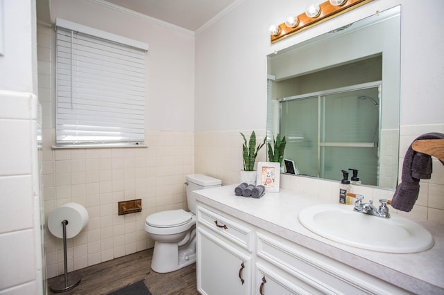 5303 46th St, Lubbock, TX 79414 - bathroom with tile walls, toilet, crown molding, a shower stall, and wood finished floors