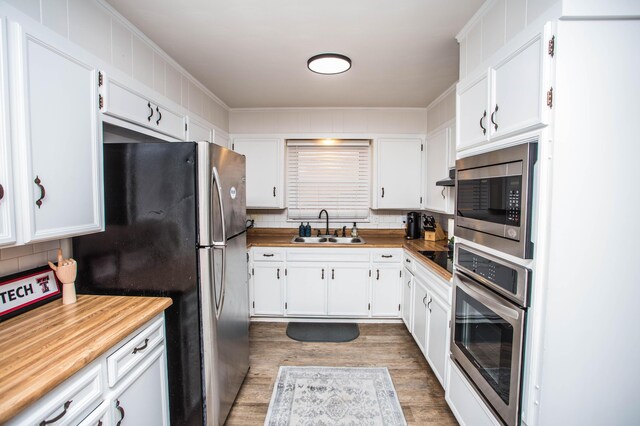 5303 46th St, Lubbock, TX 79414 - kitchen featuring a sink, backsplash, white cabinets, and stainless steel appliances