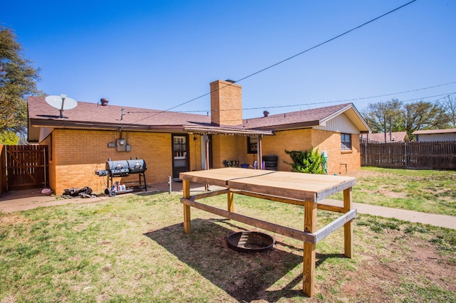 5303 46th St, Lubbock, TX 79414 - rear view of house with brick siding, fence, and a chimney