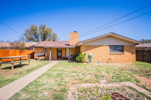 5303 46th St, Lubbock, TX 79414 - view of front of house featuring a patio, a chimney, a front lawn, brick siding, and a fenced backyard