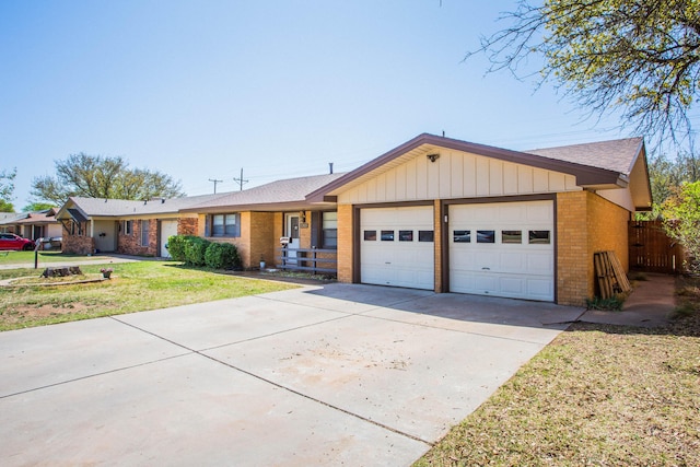5303 46th St, Lubbock, TX 79414 - ranch-style home with a front yard, an attached garage, fence, brick siding, and driveway