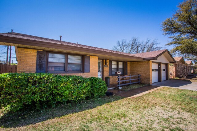 5303 46th St, Lubbock, TX 79414 - single story home with a front yard, fence, brick siding, a garage, and concrete driveway