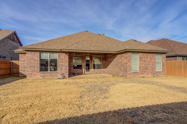 3621 121st St, Lubbock, TX 79423 - rear view of house featuring a fenced backyard, brick siding, and roof with shingles