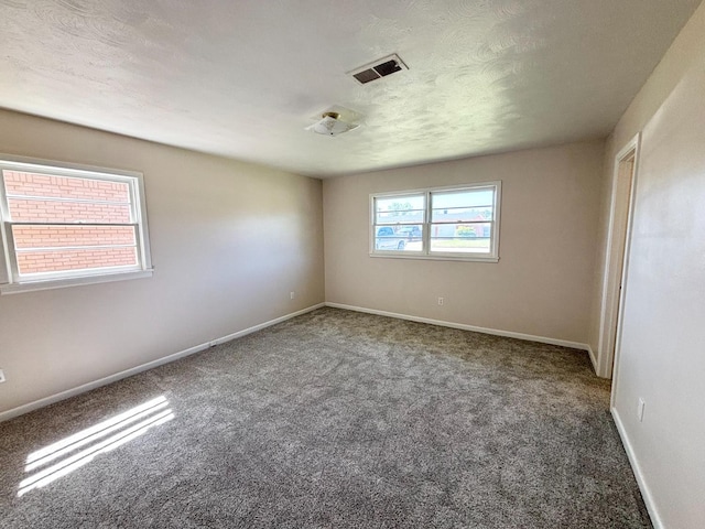 carpeted spare room featuring a textured ceiling