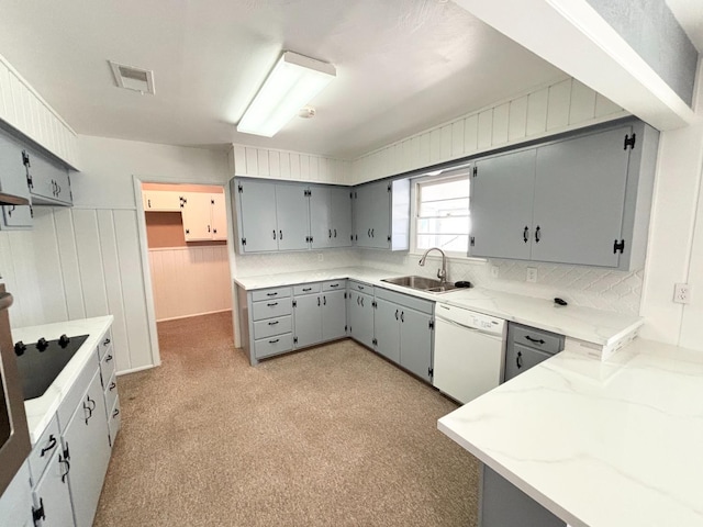 kitchen with gray cabinets, sink, white dishwasher, kitchen peninsula, and light stone countertops