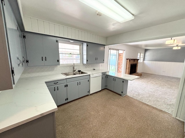 kitchen featuring white dishwasher, sink, plenty of natural light, and gray cabinets