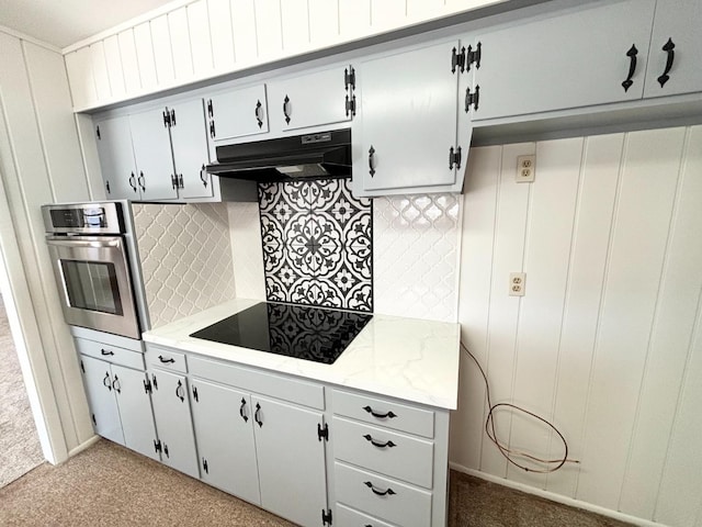 kitchen featuring tasteful backsplash, black electric stovetop, and stainless steel oven