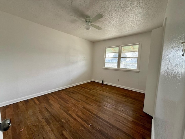 empty room featuring ceiling fan, dark wood-type flooring, and a textured ceiling