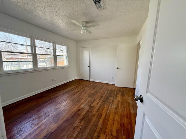 unfurnished bedroom with ceiling fan, dark wood-type flooring, and a textured ceiling