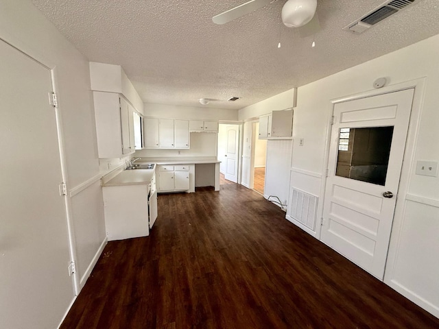 kitchen featuring sink, white cabinetry, a textured ceiling, dark hardwood / wood-style flooring, and ceiling fan