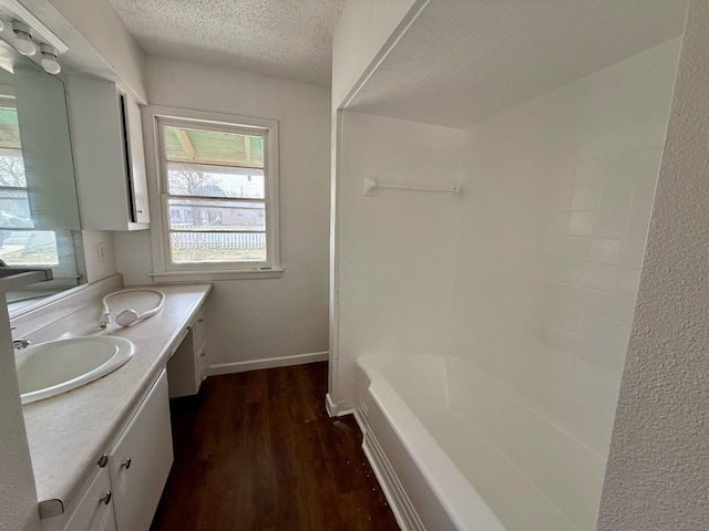 bathroom with hardwood / wood-style flooring, vanity, and a textured ceiling