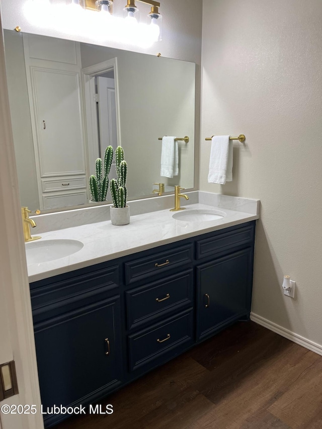 3213 75th St, Lubbock, TX 79423 - bathroom featuring double vanity, wood finished floors, and baseboards