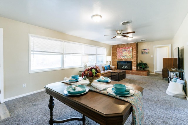 carpeted living room with ceiling fan and a fireplace