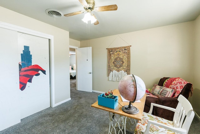 sitting room featuring ceiling fan and dark carpet