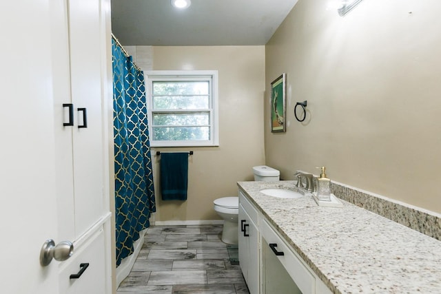 bathroom featuring walk in shower, vanity, and toilet