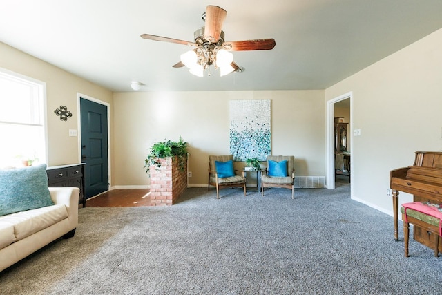 sitting room with ceiling fan and dark carpet