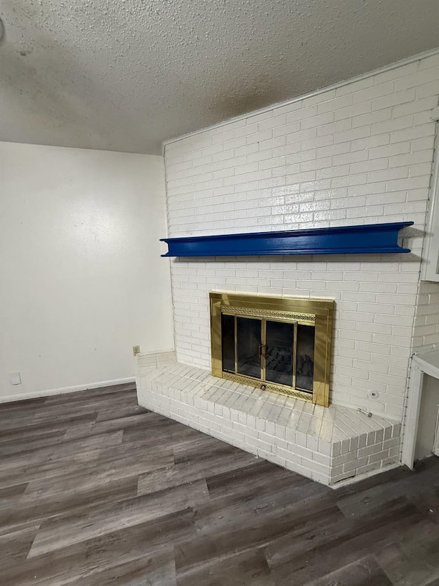 interior details with hardwood / wood-style flooring, a brick fireplace, and a textured ceiling