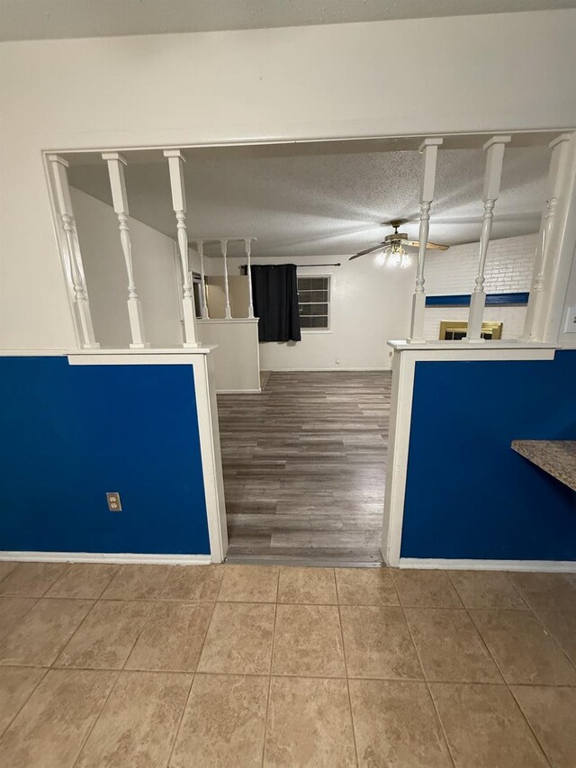 interior space featuring ceiling fan, tile patterned floors, and a textured ceiling