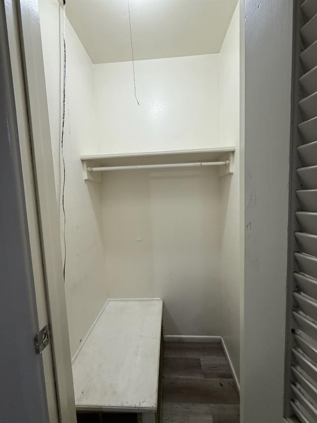 walk in closet with dark wood-type flooring