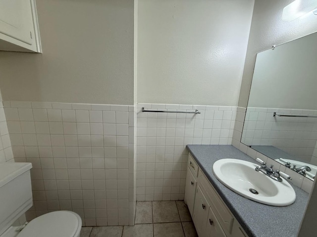 bathroom featuring tile walls, vanity, tile patterned flooring, and toilet