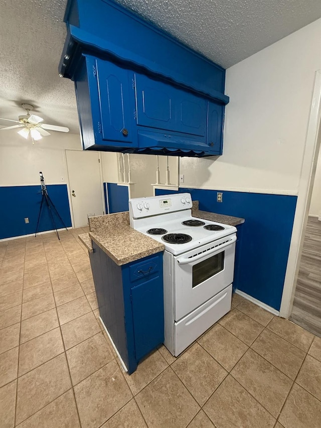 kitchen featuring blue cabinets, a textured ceiling, light tile patterned floors, white electric stove, and ceiling fan