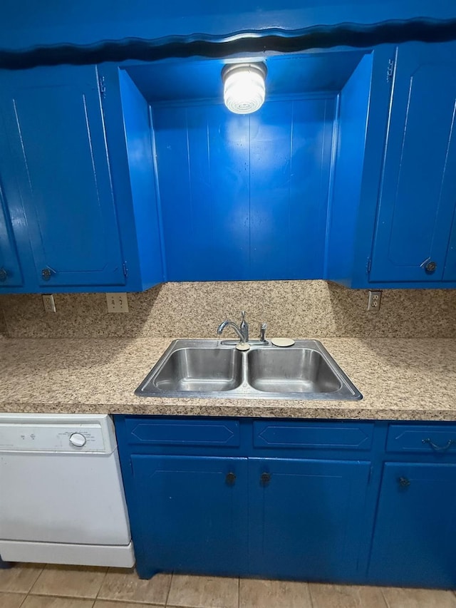 kitchen featuring blue cabinetry, dishwasher, sink, and light tile patterned floors