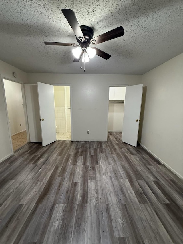 unfurnished bedroom with ceiling fan, dark hardwood / wood-style floors, a closet, and a textured ceiling