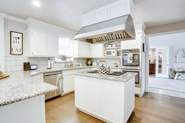 kitchen with sink, white cabinets, island exhaust hood, light stone counters, and stainless steel appliances