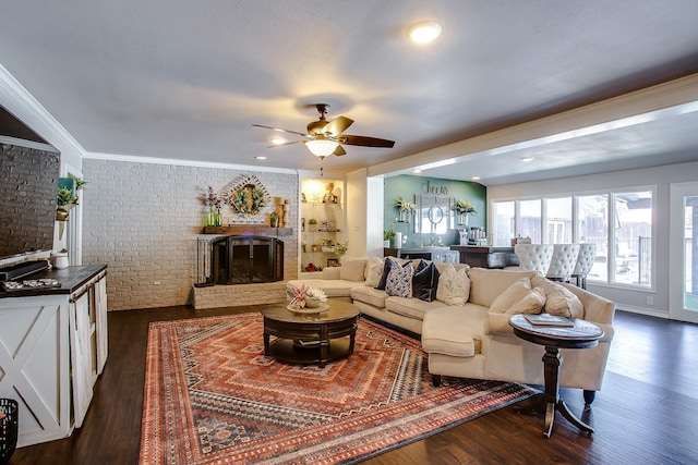 living room featuring dark wood-type flooring, ornamental molding, brick wall, and a fireplace