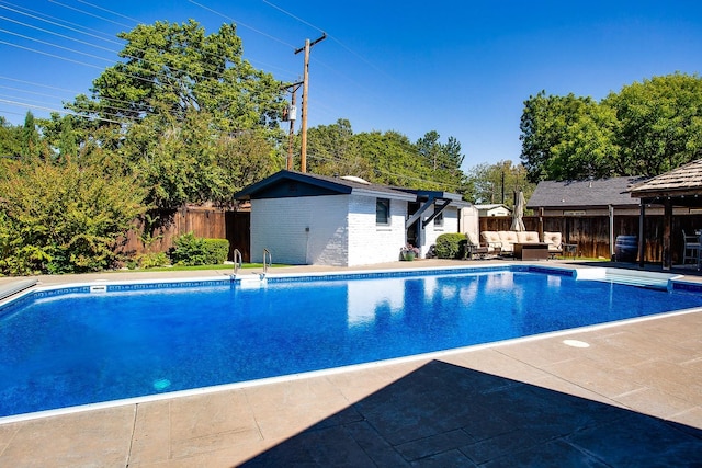 view of pool featuring an outdoor living space, a patio, and an outbuilding