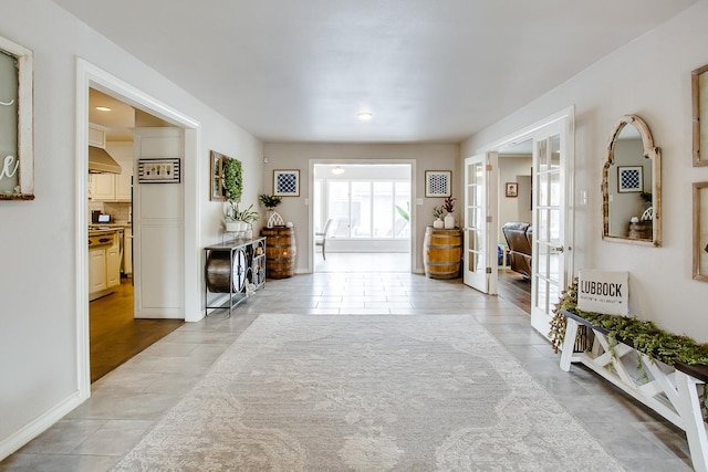 hallway with french doors and light tile patterned flooring