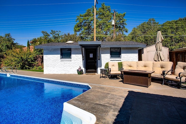 view of pool featuring a patio, an outdoor hangout area, and an outbuilding