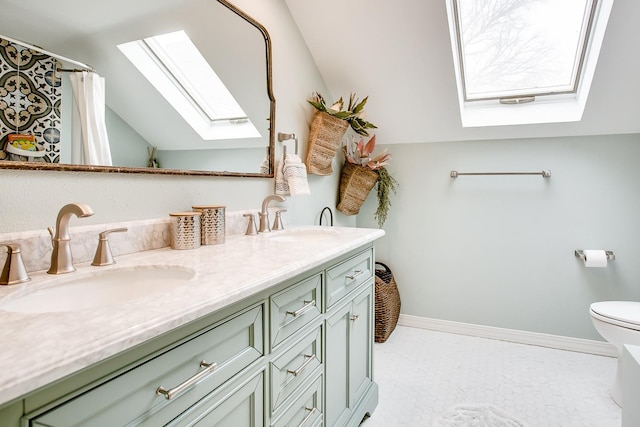 bathroom with vanity, vaulted ceiling with skylight, and toilet