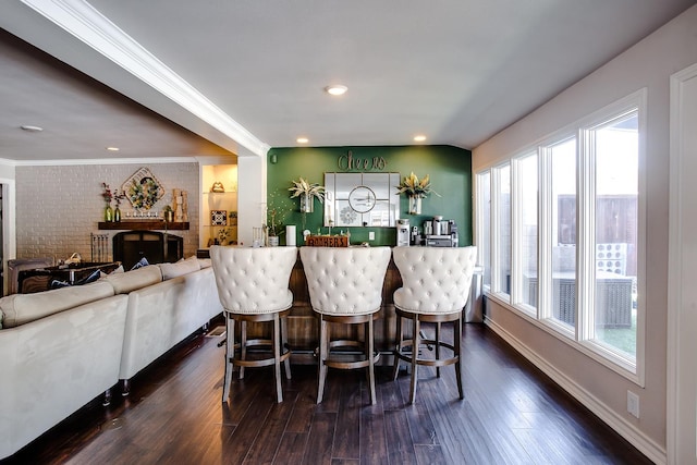 interior space featuring crown molding, brick wall, dark wood-type flooring, and a wealth of natural light